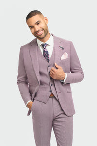 Man wearing a light purple suit with a white shirt and patterned tie on a light gray background